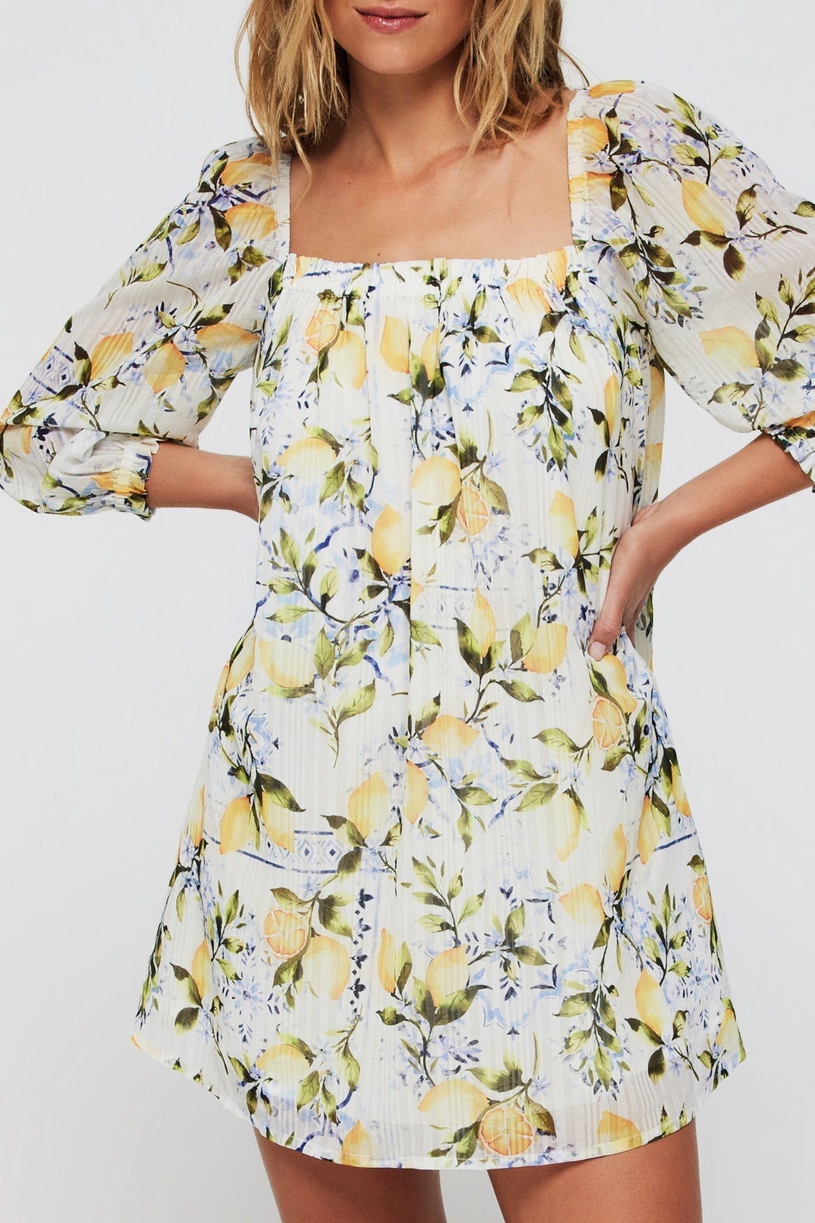Lina Long Sleeve Cover Up Mini Dress in Lemons features a square neckline and puff sleeves with a vibrant lemon floral print, ideal for beach layering.