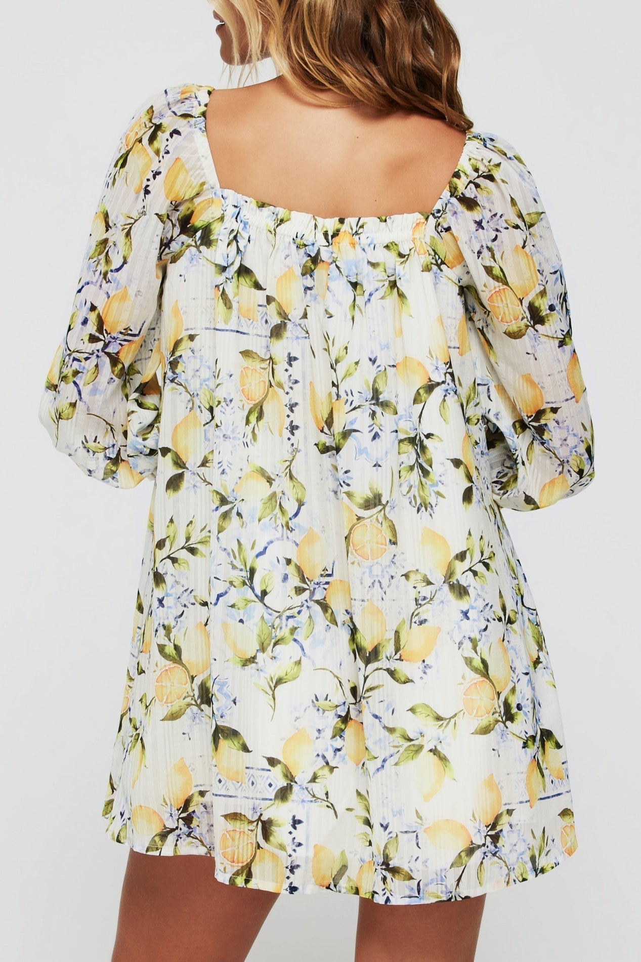 Back view of Lina Long Sleeve Cover Up Mini Dress in Lemons showing gathered elastic neckline and flowy fit, perfect for swimwear cover up style.