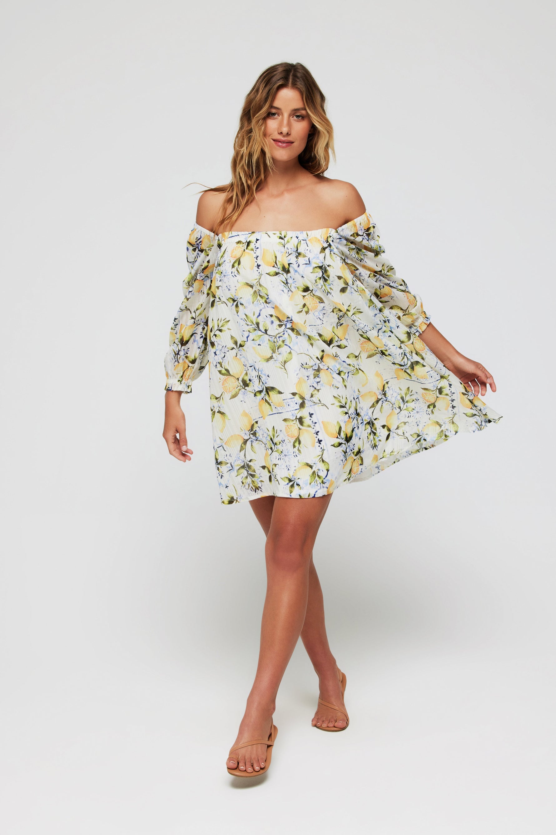 Model wearing Lina Long Sleeve Cover Up Mini Dress in Lemons off-shoulder with flowy silhouette, showcasing swimwear cover up fashion for summer.
