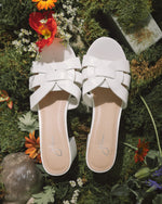 Nori | White Sandals by J.Adams styled in a floral outdoor setting, emphasizing their fresh and fashionable appeal.