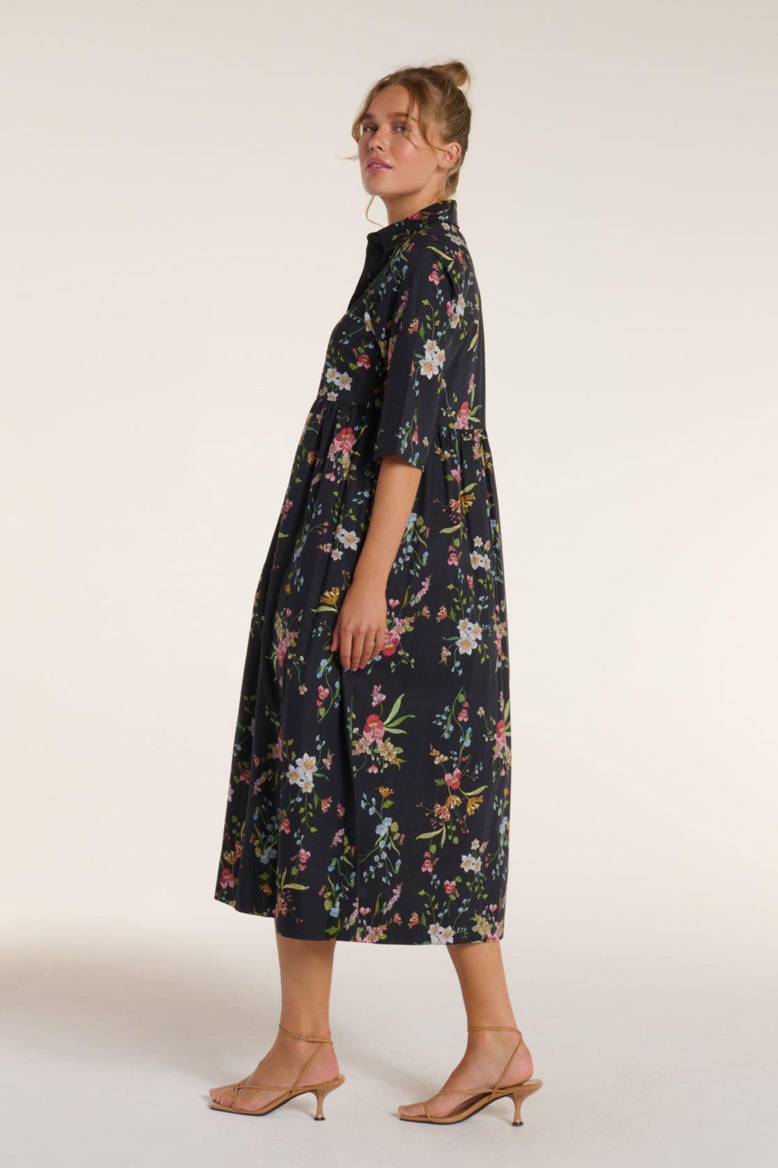 Side view of Francesca Collared Belted Maxi Dress in Black Floral highlighting its flattering A-line shape and floral pattern for chic comfort.