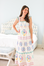 Olivia Maxi Dress in Graceful Garlands features a tiered silhouette with pastel floral patterns, perfect for spring and summer occasions.