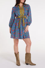 Halle Collared Belted Mini Dress in Blue Floral featuring puff sleeves, yellow tie belt, and floral print, paired with cowboy boots.