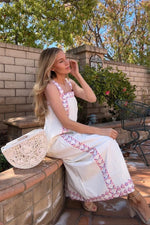 Model wearing Ava Maxi Dress in Graceful Garlands outdoors, styled with a white woven bag, showcasing its breezy and elegant design.