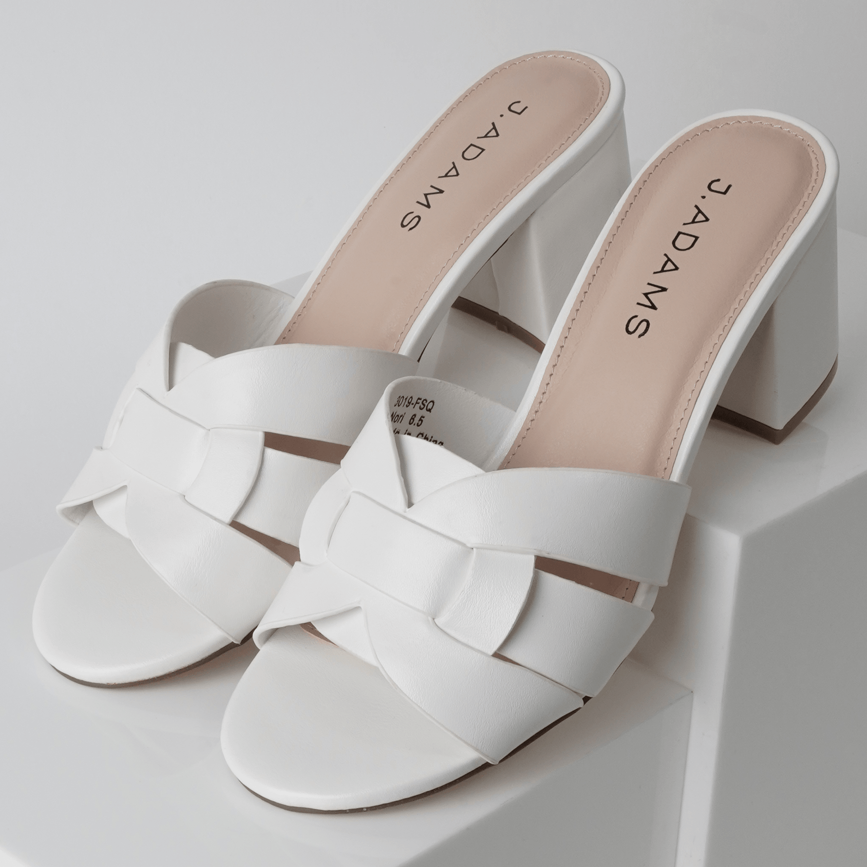 Angled view of Nori | White Sandals with mid-height block heel and elegant woven straps, ideal for versatile styling.