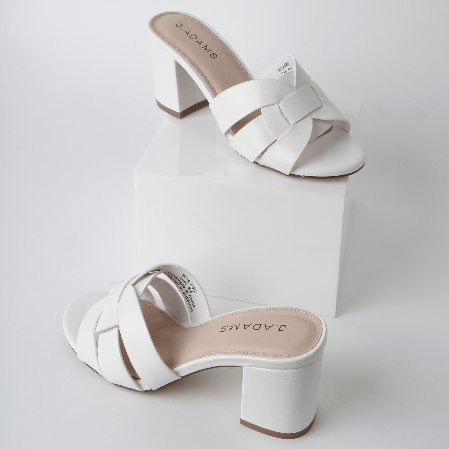 Pair of Nori | White Sandals displayed on a white platform, showcasing their modern silhouette and clean design.